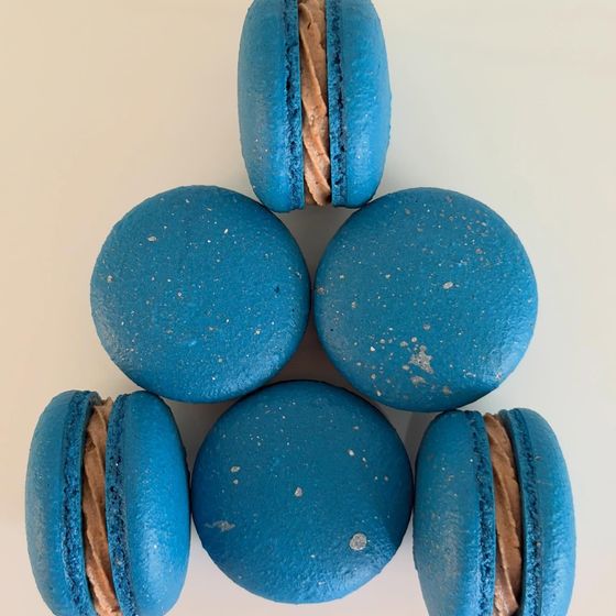 Blue Nutella macarons arranged in a triangle